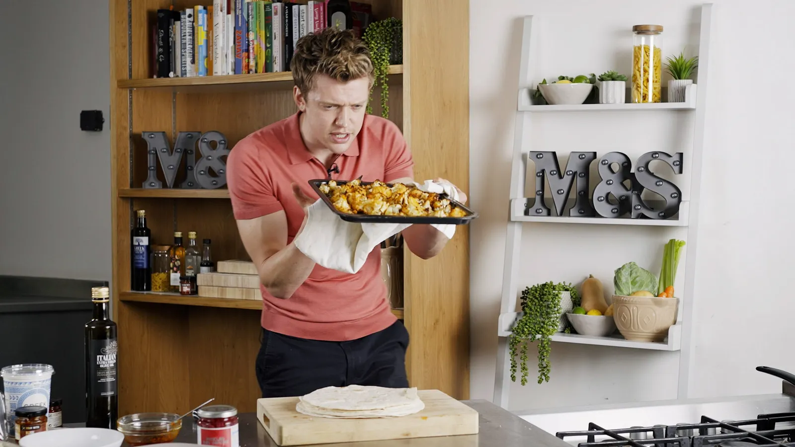 Man holding tray of food from oven during Marks and Spencers Feed your family campaign