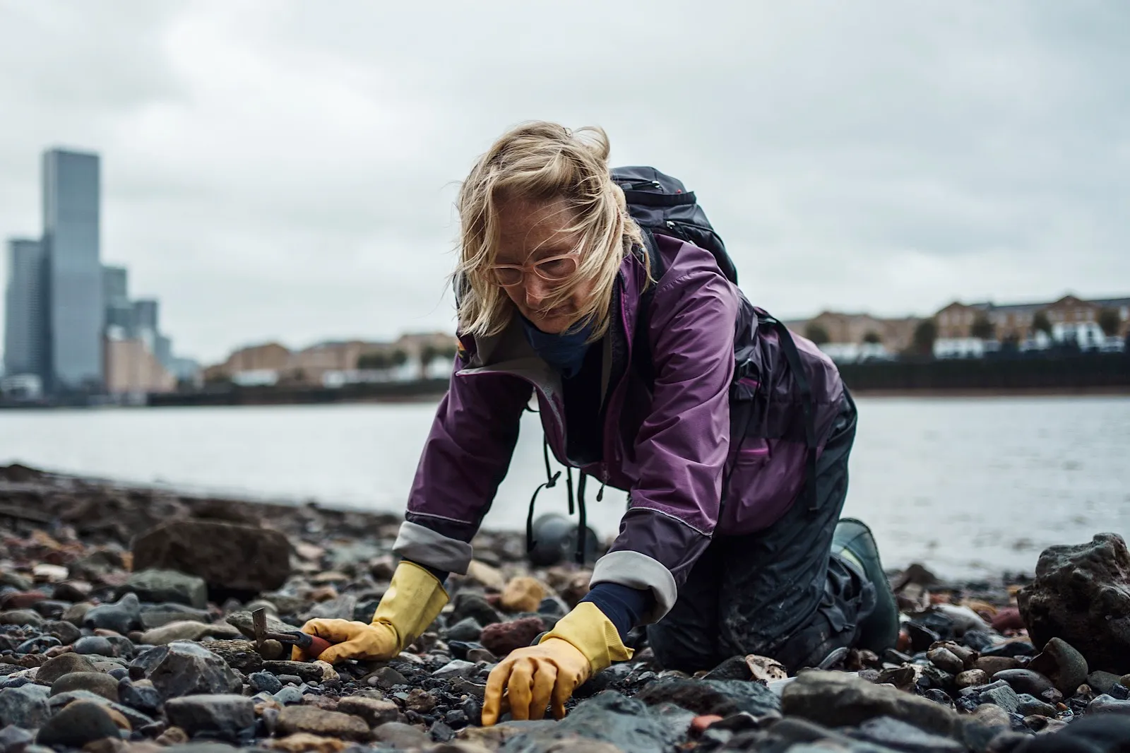 Mudlarker looking for buried treasure on banks of River Thames in London