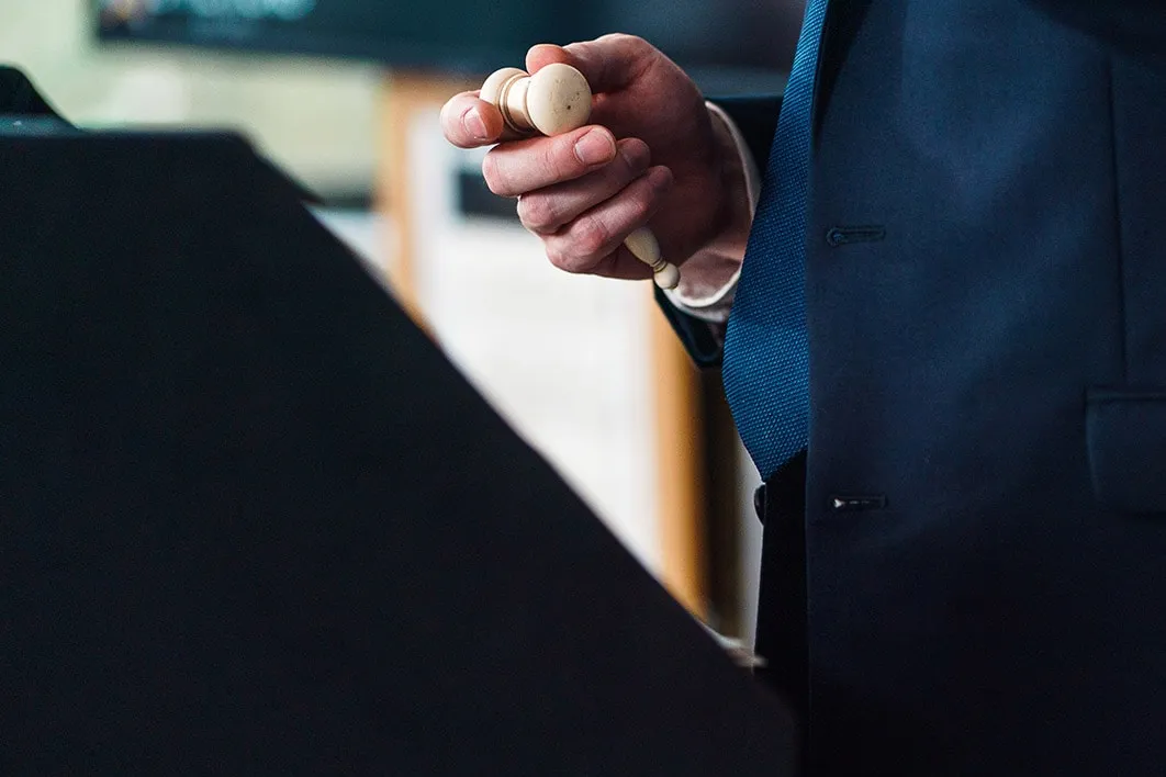 Image of man holding small auctioneers hammer
