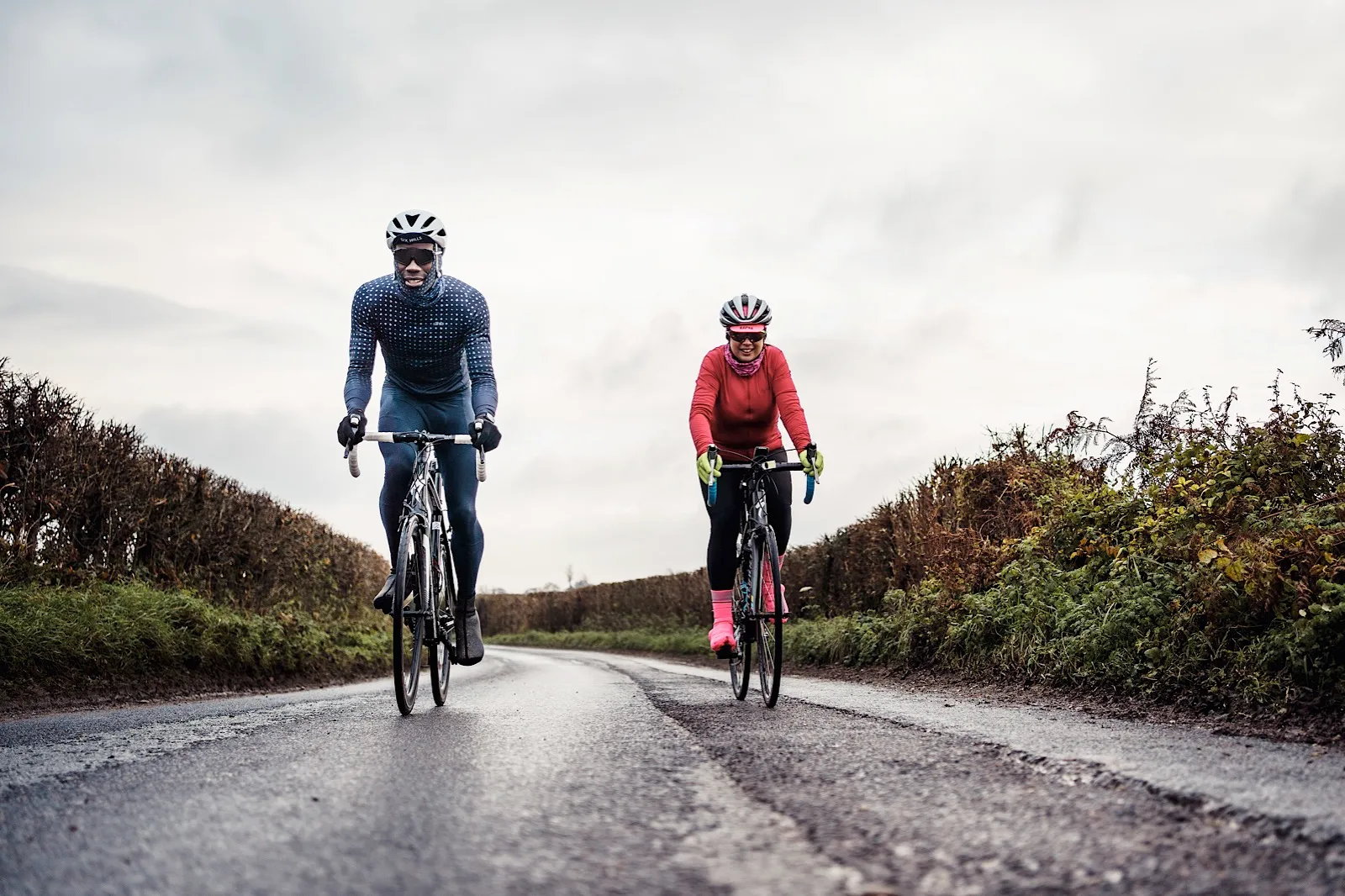 Male and female cyclists on quiet country road