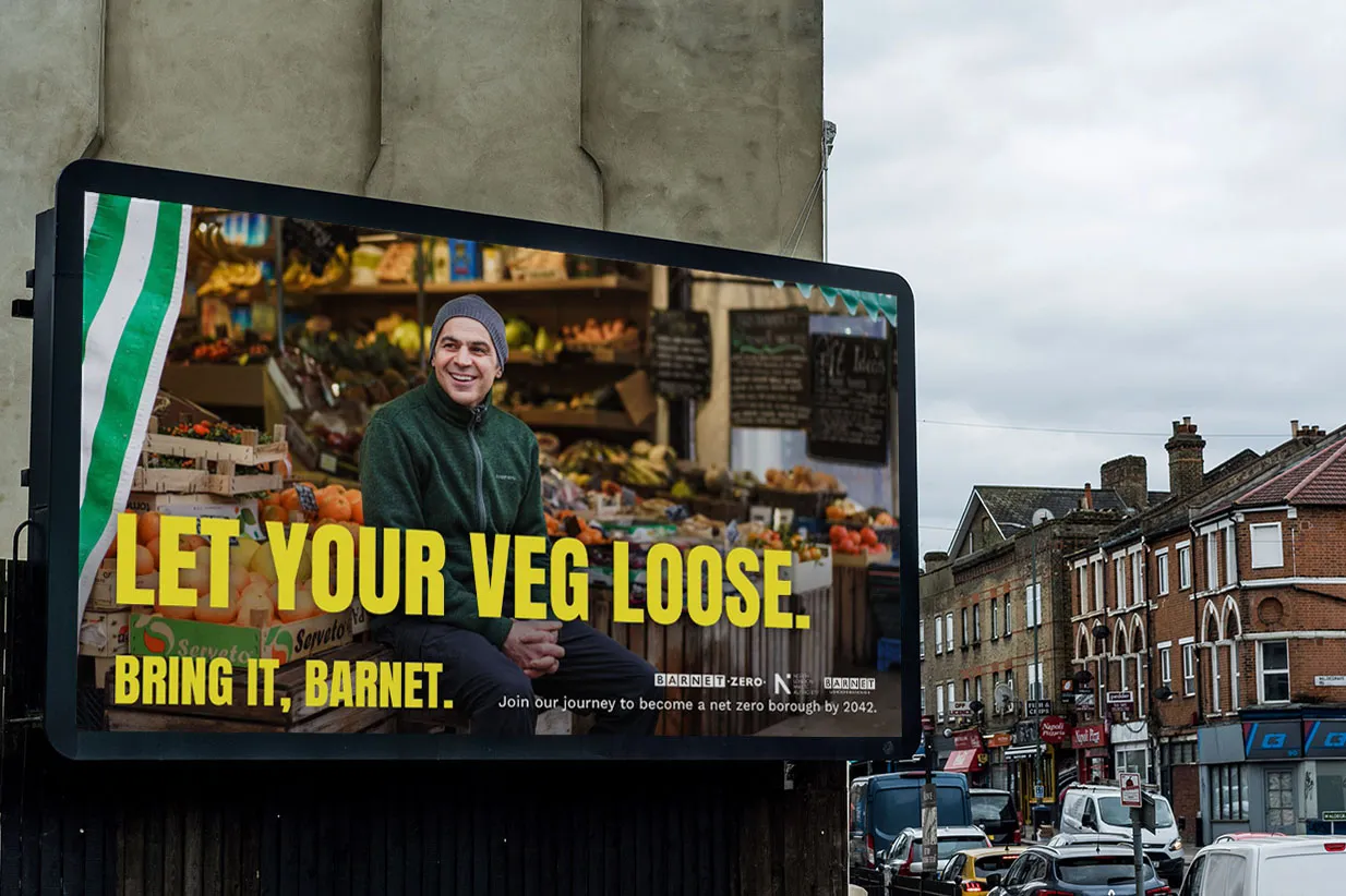 A billboard displays a man in a green sweater and gray beanie at a market stall, with the text "Let your veg loose. Bring it, Barnet." and smaller campaign details.