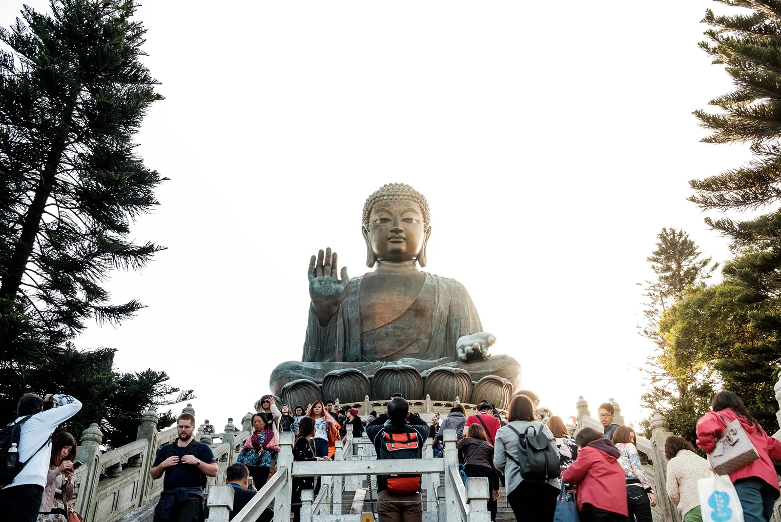 Scene showing people passing The Tian Tan Buddha statue in Hong Kong