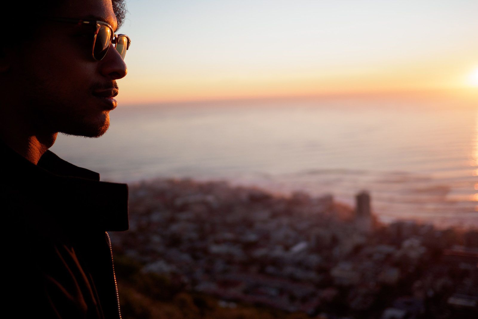 Man wearing sunglasses at sunset by the coast