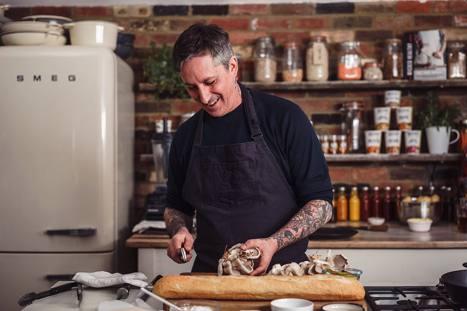 Man chopping produce in kitchen as he laughs