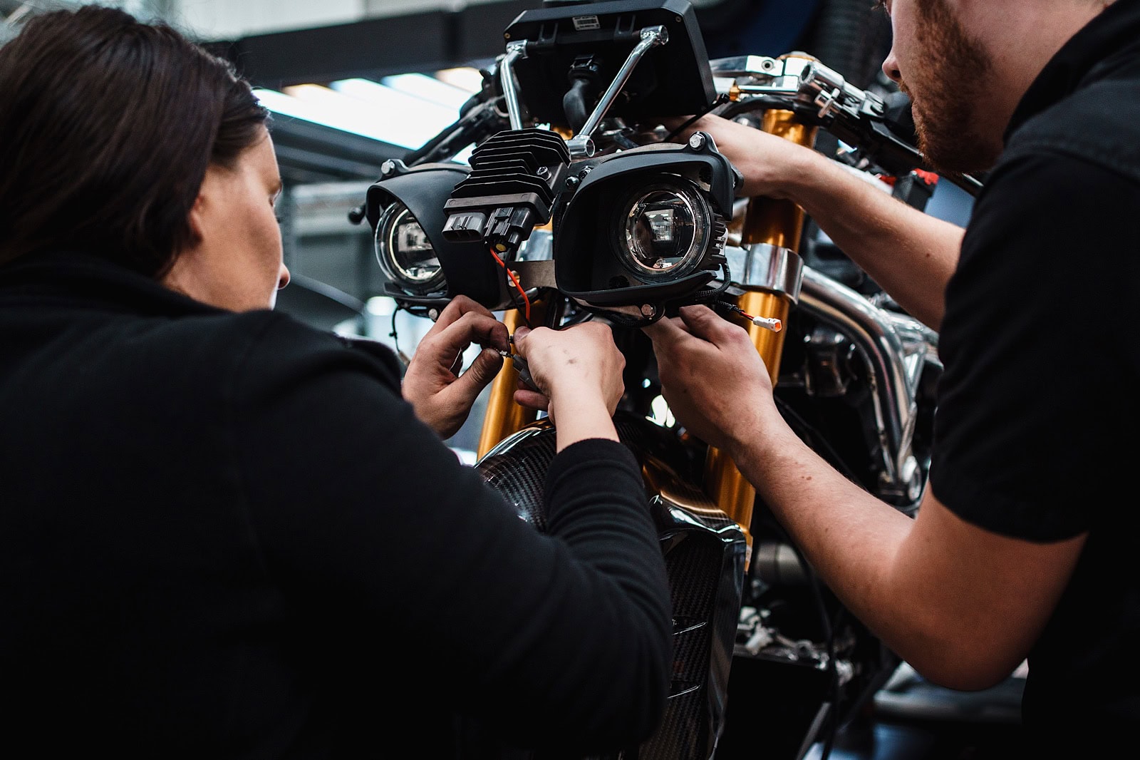 Commercial portrait of 2 people working on motorbike headlights