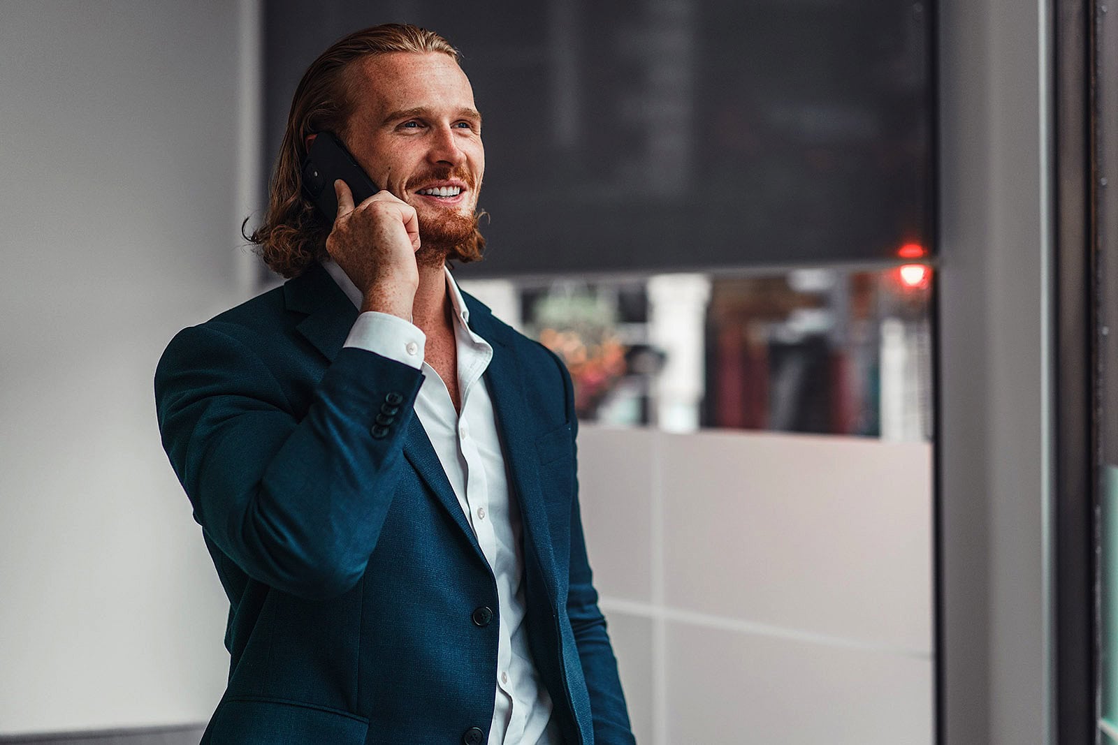 Commercial Portrait of man smiling whilst on a mobile phone