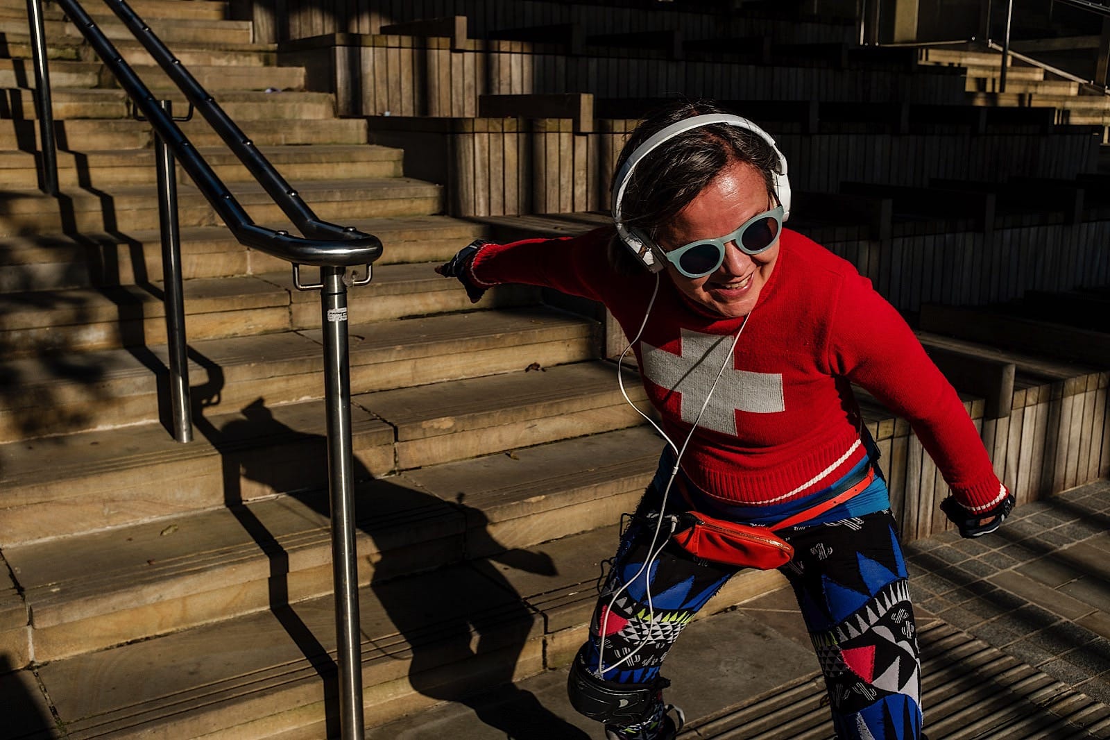 Woman skateboarding wearing sunglasses and headphones