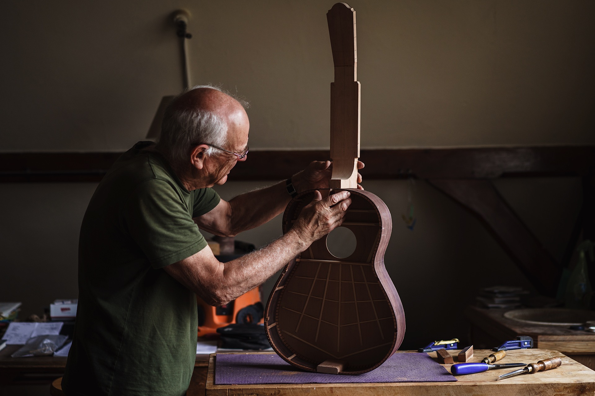 Nick Branwell, Luthier seen assembling a guitar in a workshop, surrounded by tools.