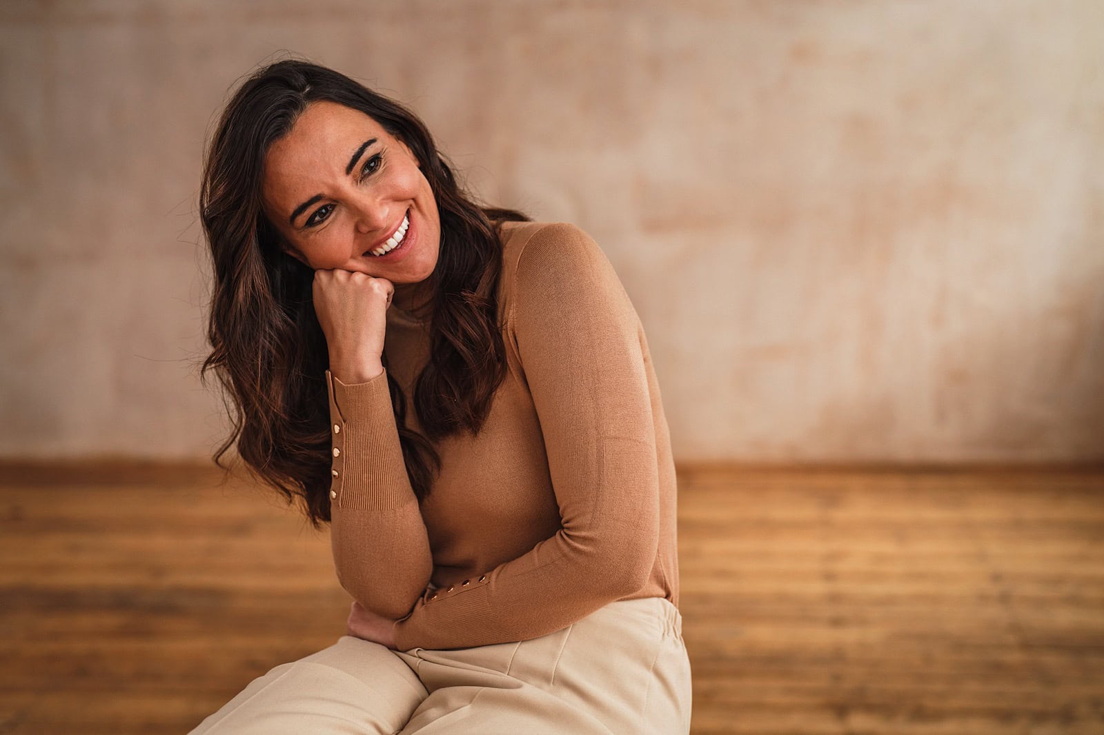Portrait of a woman resting her head on her hand smiling