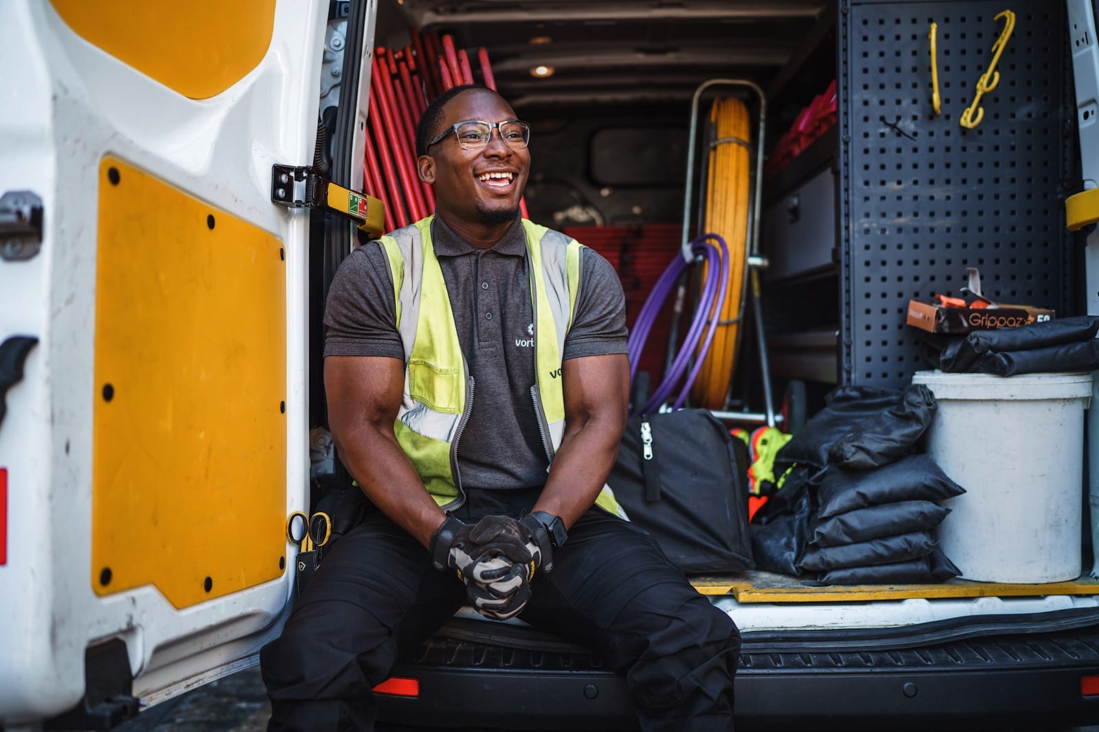 portrait of man sat in back of van smiling.