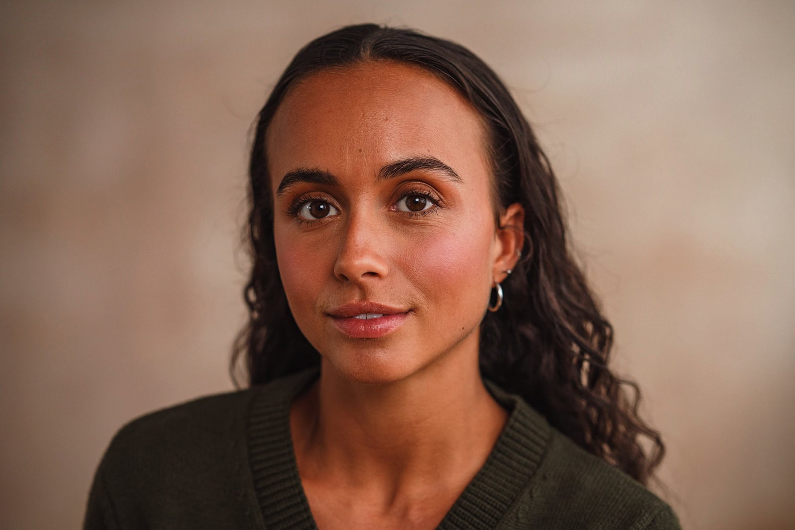 Portrait of woman with long brown hair looking directly at the camera