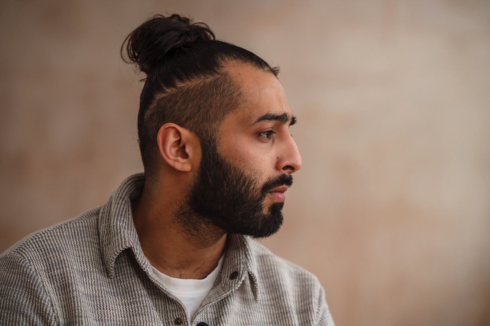 Man with manbun looking pensive during a shoot for Unmind