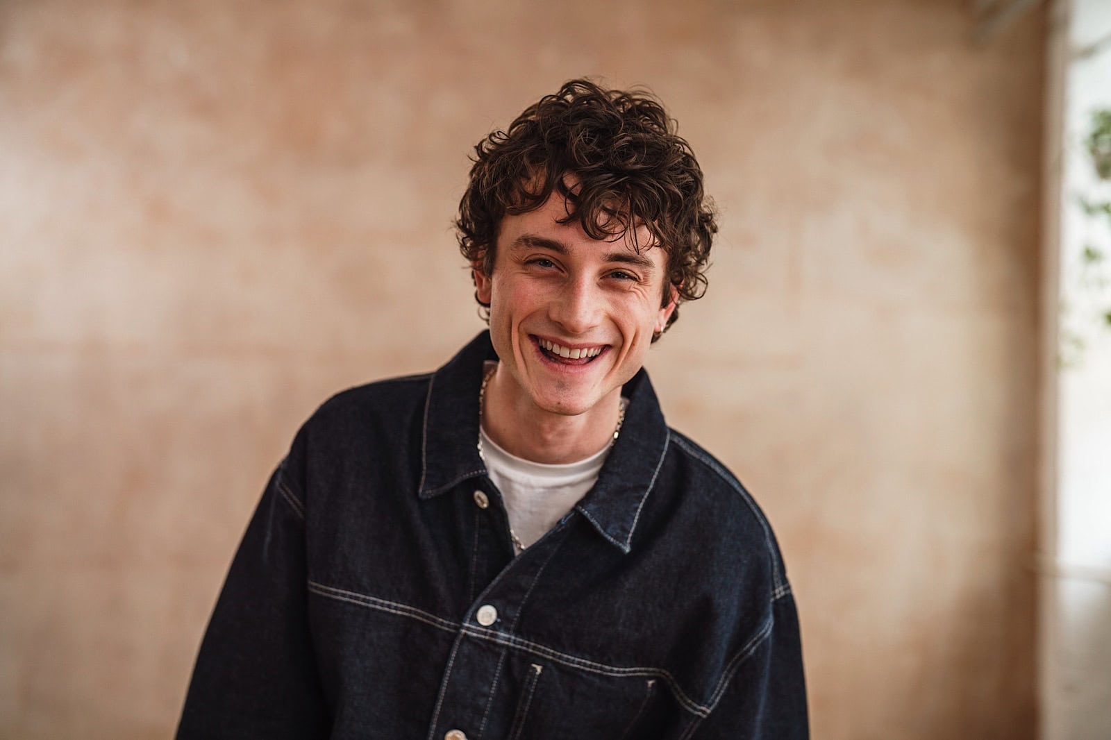 Man with curly hair laughing during a commercial studio shoot