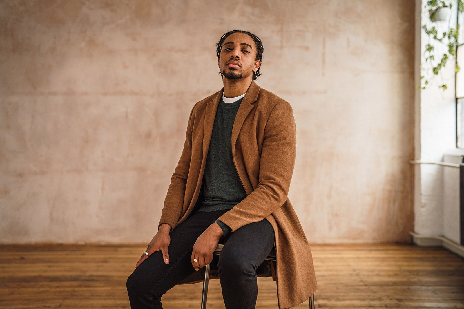 Man sat on a stool during a studio photoshoot